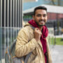 side-view-smiley-man-holding-backpack